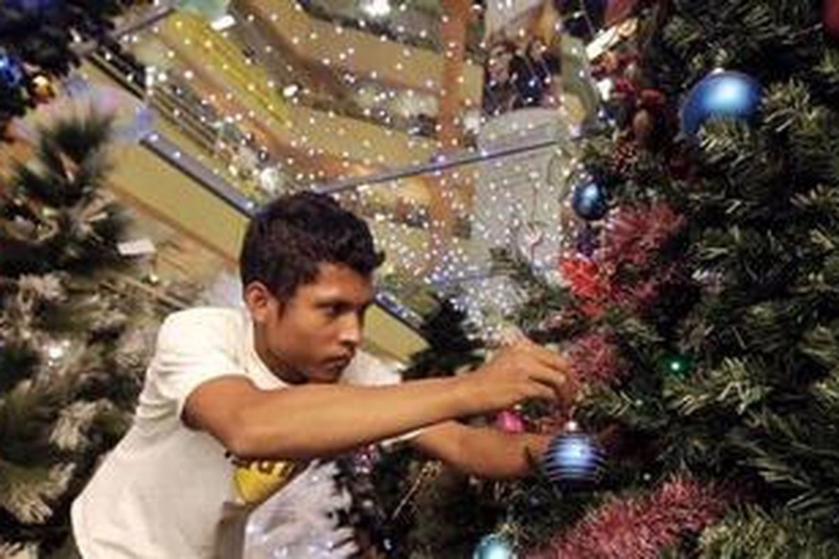Karyawan menghias pohon natal dari bahan plastik sebelum dijual di ITC Mangga Dua, Jakarta Utara, Sabtu (11/12/2010). Berbagai pernak-pernik Natal seperti boneka, hiasan pohon natal dan pohon natal plastik dijual mulai Rp 20.000 hingga Rp 11 juta. 