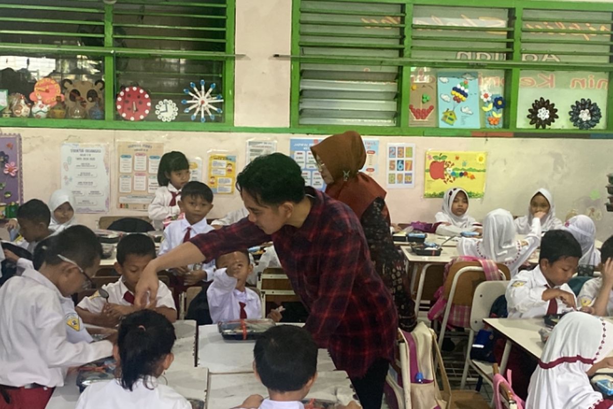 Wakil Presiden terpilih, Gibran Rakabuming Raka, saat membagikan nasi gratis di SDN Klampis Ngasem 3 Surabaya, Kamis (1/8/2024).