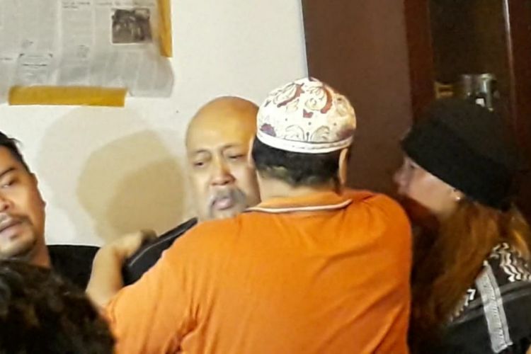 Indro Warkop di samping jenazah istrinya, Nita Octobijanthy, yang terbaring di rumah duka Jalan Kayu Putih Tengah IIA nomor 4, Jakarta Timur, Rabu (10/10/2018) dini hari.