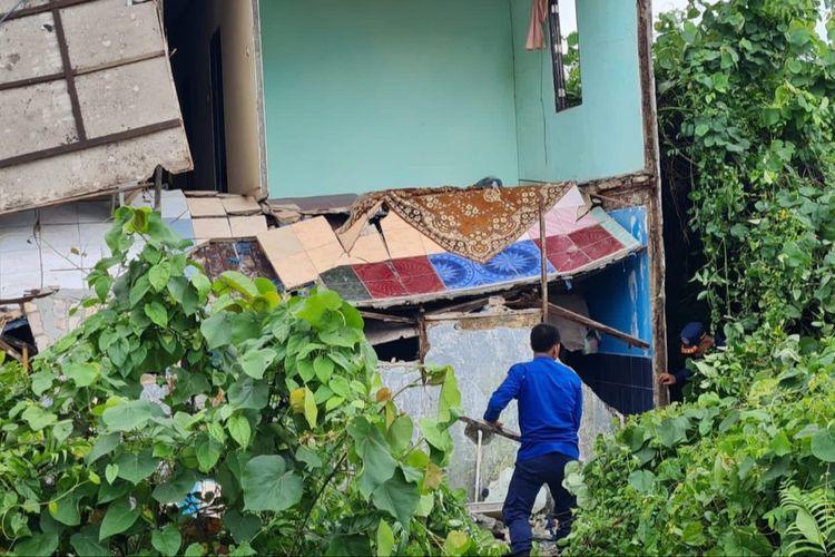 Seorang petugas DPKP Banjarmasin membantu mengevakuasi barang penghuni kos dalam kejadian ambruknya rumah kos berlantai dua di Jalan Sultan Adam, Banjarmasin, Kalsel pada, Selasa (7/3/2023). 