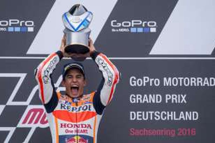 Pebalap Repsol Honda asal Spanyol, Marc Marquez, mengangkat trofi juara setelah finis di urutan pertama pada GP Jerman di Sachsenring, Minggu (17/7/2016).