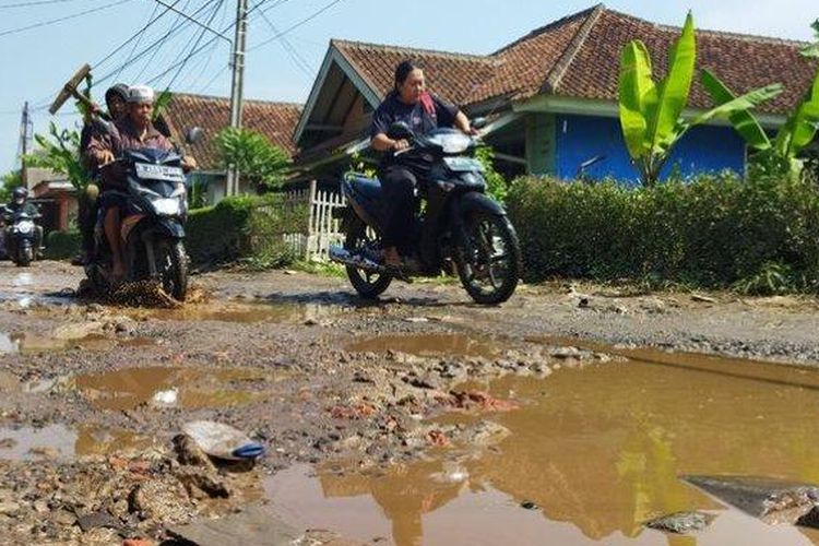 Pengendara sepeda motor saat melewati jalan rusak di Batujajar, Kabupaten Bandung Barat. 