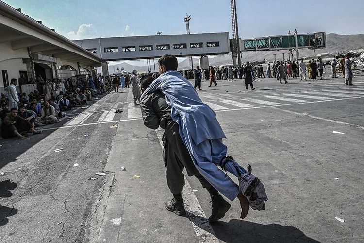 Seorang pria terluka di tengah kekacauan saat warga saling berebut untuk melarikan diri ke luar negeri, di Bandara Kabul, Afghanistan, Senin (16/8/2021). Bandara Kabul dilanda kekacauan ketika ribuan orang mencoba melarikan diri dari Taliban yang dilaporkan segera menguasai penuh Afghanistan.