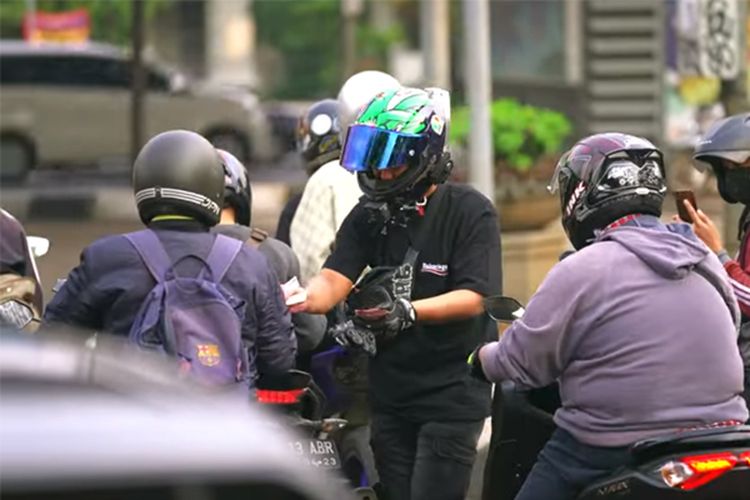 Pengendara moge Kawasaki Ninja H2 yang merupakan YouTuber Doni Salmanan bagi-bagi uang di lampu merah dan pinggir jalan