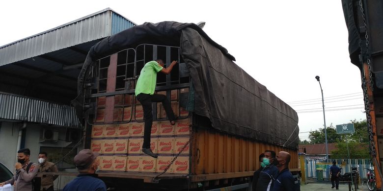 Pekerja menutup terpal truk pengangkut minyak goreng yang akan didistribusukan dari PT Salim Ivomas Pratama di Kecamatan Lubuk Pakam, Deli Serdang pada Rabu (23/2/2022).