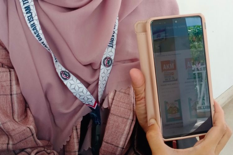 Kepala Sekolah SDIT Uwais Al Qorni menunjukan aplikasi perpustakaan digital sekolahnya yang telah terpasang di ponsel android miliknya.