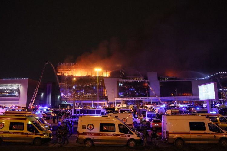 Kendaraan layanan darurat terlihat di luar gedung Balai Kota Crocus yang terbakar dalam penembakan di konser Moskwa pada 22 Maret 2024. Insiden ini menyebabkan 137 orang tewas.