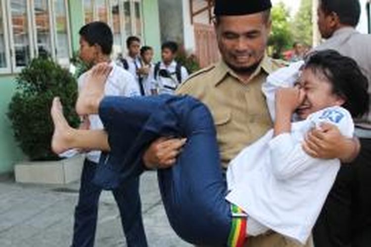 Seorang guru menggendong siswi SMP Muhammadiayh Mungkid Magelang yang kesurupan, Senin (11/11/2013).