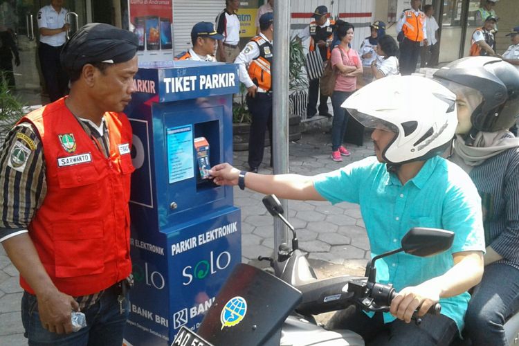 Warga menempelkan kartu e-parkir di mesin parkir elektronik non-tunai di kawasan Singosaren, Serengan, Solo, Jateng, Jumat (9/3/2018).