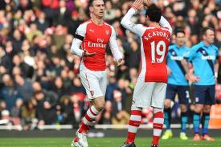 Bek Arsenal, Laurent Koscielny (kiri), seusai mencetak gol ke gawang Stoke City pada lanjutan Premier League di Stadion Emirates, Minggu (11/1/2015). 