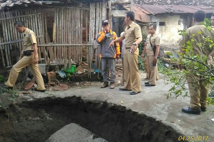 Petugas mengecek sumur yang amblas di Kecamatan Puncu Kabupaten Kediri, Jawa Timur. 