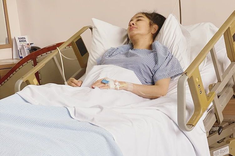 Penyanyi dangdut Uut Permatasari terbaring lemas di kasur rumah sakit. 