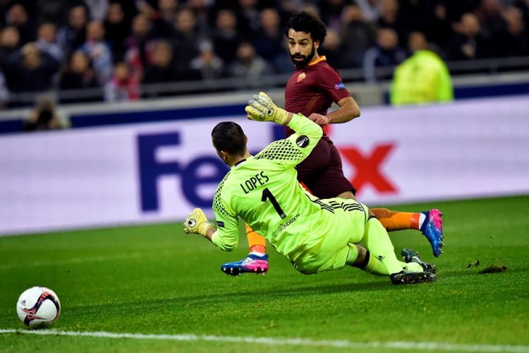 Gelandang AS Roma asal Mesir, Mohammed Salah (kanan), melepaskan tembakan dan mencetak gol ke gawang Lyon yang dikawal Anthony Lopes dalam pertandingan leg pertama babak 16 besar Liga Europa di Stadion Parc Olympique Lyonnais di Decines-Charpieu, Kamis (9/3/2017).