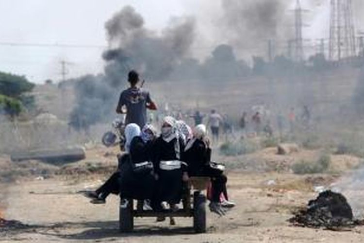 Perempuan Palestina duduk di belakang kereta saat terjadi bentrokan dengan tentara Israel di dekat Nahal Oz, Gaza, 10 Oktober 2015.