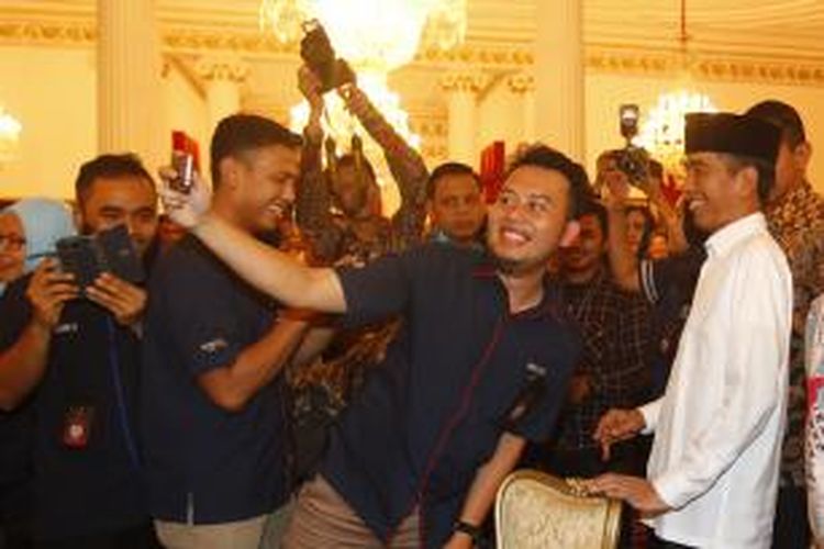 Presiden Joko Widodo berfoto dengan wartawan yang bertugas di lingkungan Istana Presiden saat acara buka puasa bersama di Istana Negara, Jakarta, Senin (6/7/2015). Acara ini juga dihadiri oleh sejumlah menteri Kabinet Kerja dan diisi dengan shalat berjamaah dengan wartawan.