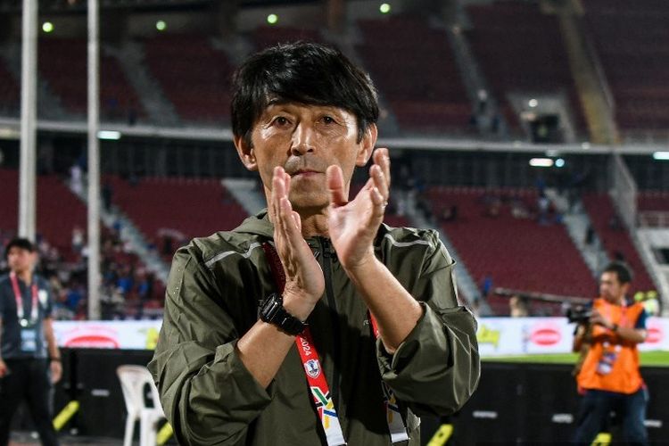 Masatada Ishii menyapa para pendukung di akhir pertandingan sepak bola grup ASEAN Championship 2024 antara Thailand vs Kamboja di Stadion Nasional Rajamangala di Bangkok pada 20 Desember 2024. (Foto oleh Amaury PAUL / AFP)