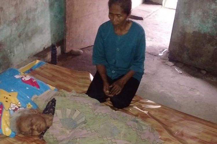 TAK BERDAYA -Nenek Kadiyem ( 85) ,warga Dusun Ngulubang, Desa Mlilir, Kecamatan Dolopo, Kabupaten Madiun tergolek lemas tak berdaya tidur sebatangkara di rumahnya, Senin ( 6 / 3 / 2017) . Untuk makan dan minum, tetangganya Sulami (duduk) menyuapi setiap hari.