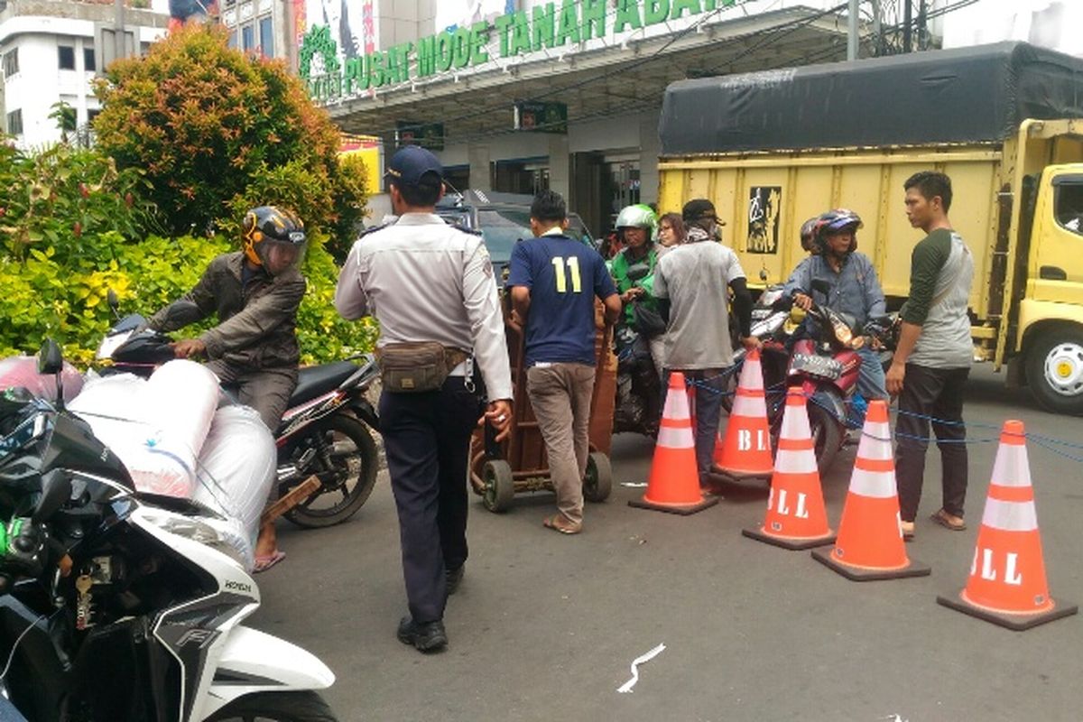 Porter di Pasar Tanah Abang masih nekat menerobos traffic cone yang digunakan untuk menutup akses berputar kendaraan di depan Blok A, Rabu (10/1/2018).