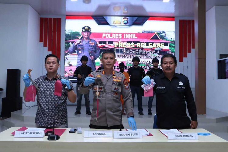Kapolres Inhil AKBP Norhayat (tengah) bersama anggotanya memperlihatkan barang bukti badik dan senjata api yang disita dari pelaku perampokan, di Kabupaten Inhil, Riau, Sabtu (11/3/2023).