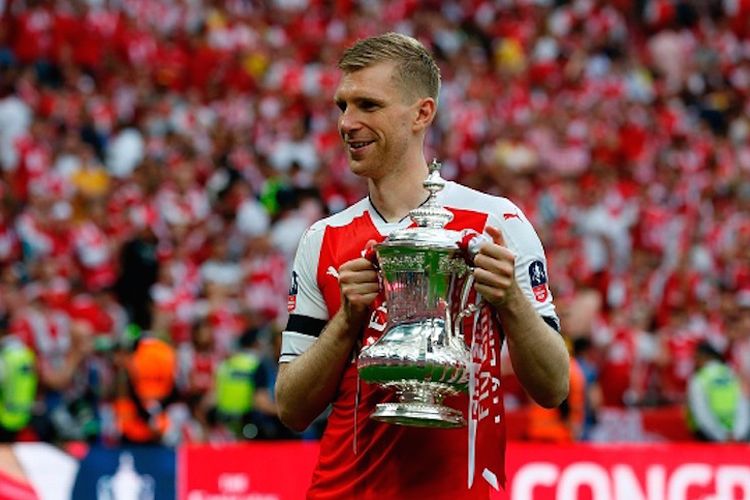 Bek asal Jerman, Per Mertesacker, berposes dengan trofi Piala FA seusai Arsenal menang atas Chelsea pada laga final di Stadion Wembley, Sabtu (27/5/2017). 