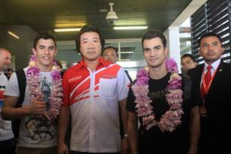 Pebalap Repsol Honda, Marc Marquez (kiri) dan Dani Pedrosa (kanan), berpose bersama Agustinus Indraputra (tengah) selaku General Manager Marketing Planning Analysis Division AHM saat tiba di Bandara Soekarno-Hatta, Cengkareng, Senin (20/10/2014).