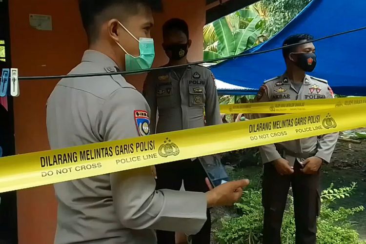 Polisi berjaga di depan rumah seorang perempuan yang ditemukan tewas membusuk di kamarnya di Jalan Baru, Desa Babana, Mamuju Tengah, Sulawesi Barat.