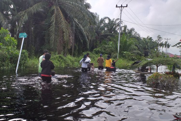 Warga mengarungi banjir untuk melihat kondisi rumahnya di Kelurahan Bumi Ayu, Kecamatan Dumai Selatan, Kota Dumai, Riau, Sabtu (30/10/2021).