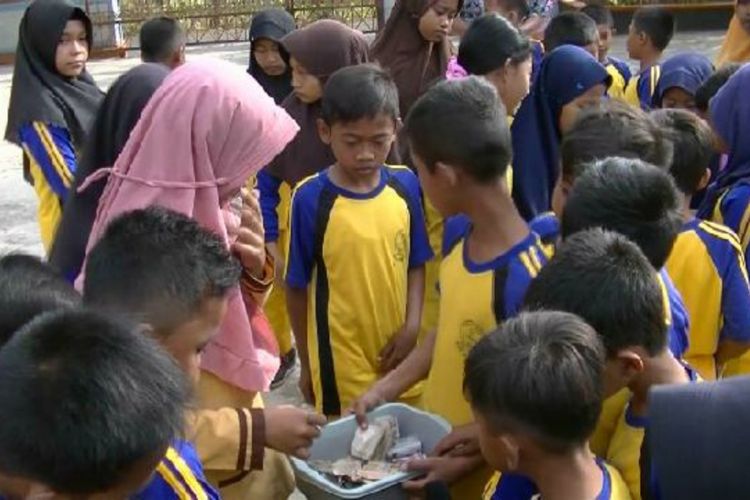 Siswa SD Mentel 1, Kecamatan Tanjungsari, Gunungkidul, mengumpulkan uang saku untuk membantu memberikan honor guru, Jumat (14/9/2018).