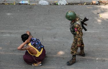 Seorang tentara berdiri di belakang seorang pria yang ditahan, dalam demonstrasi menentang kudeta di Mandalay, Myanmar, pada 3 Maret 2021.