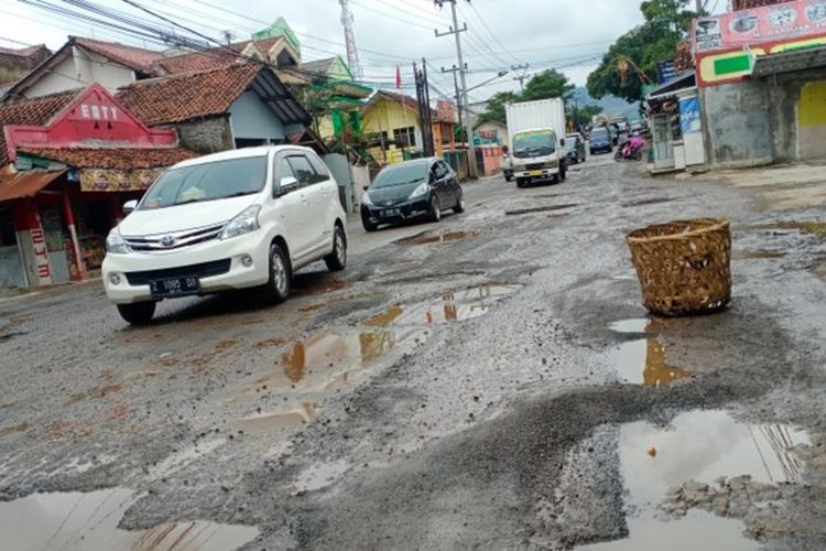 Ilustrasi mobil melintasi jalanan rusak.