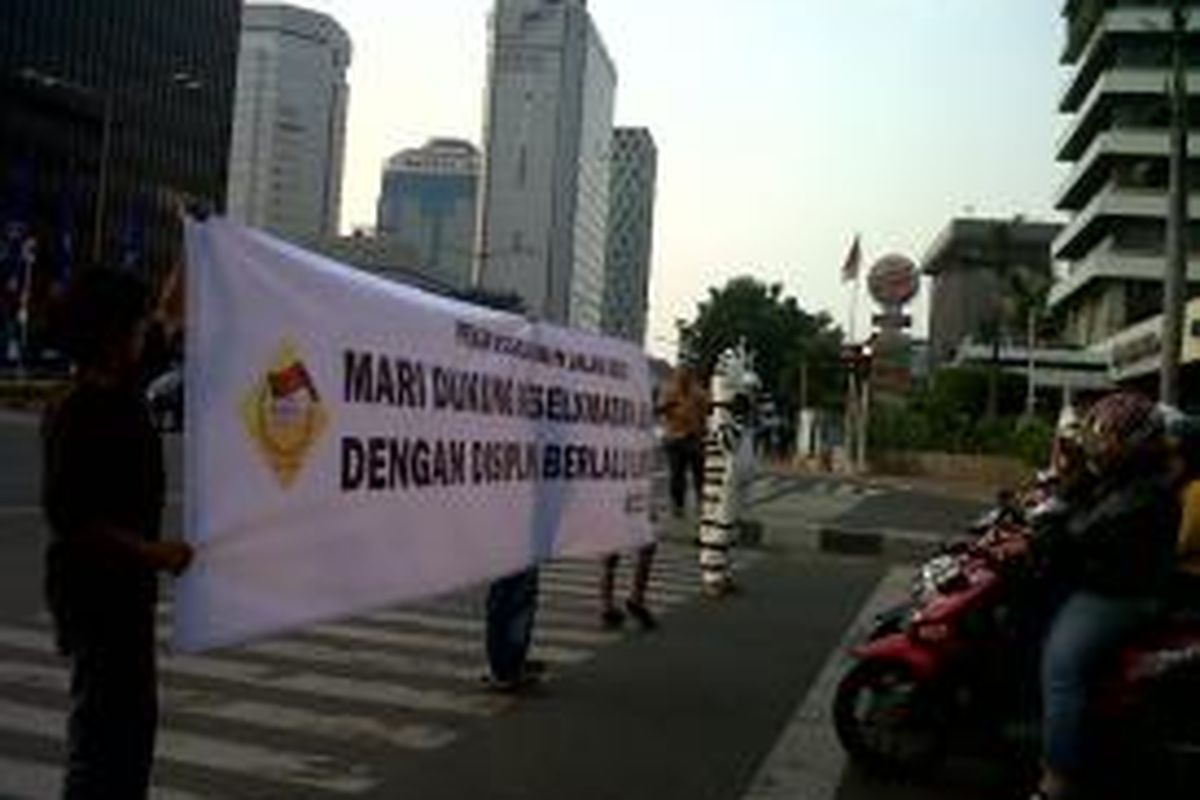 Koalisi Pejalan Kaki memberikan edukasi lalu lintas kepada pengendara sepeda motor dan mobil, kepada para pejalan kaki yang ingin menyebrang di Zebra Cross, di Jalan M.H Thamrin, Jakarta, Rabu (25/09/2013).