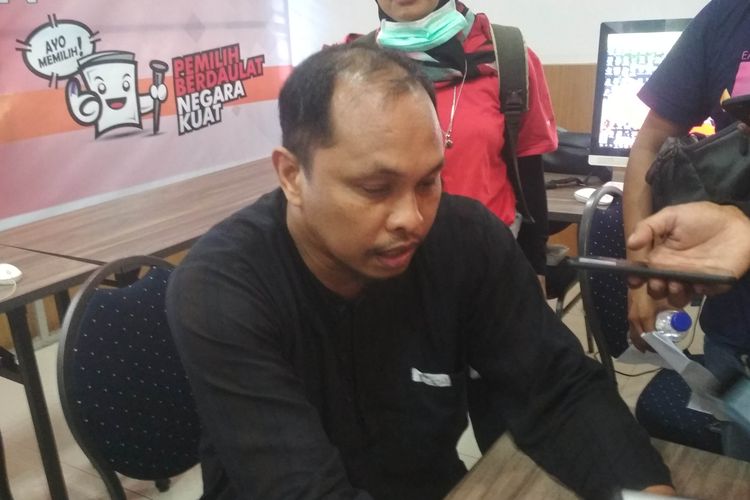 Komisioner KPU Sulsel Uslimin saat memperlihatkan laporan pihaknya dianiaya oleh para pemilih saat penghitungan suara, Jumat (19/4/2019).