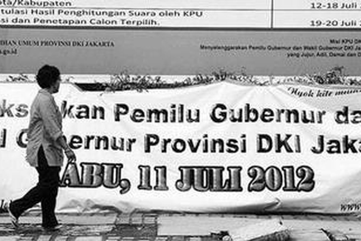 Pejalan kaki melintas di depan baliho berukuran besar yang berisi jadwal Pemilu Kepala Daerah DKI Jakarta 2012 di pinggir Jalan Budi Kemulyaan, Jakarta Pusat, Rabu (14/3/2012). Saat ini, Pilkada DKI Jakarta memasuki tahap pendaftaran pasangan calon gubernur dan wakil gubernur.