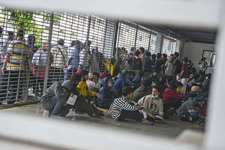 Sejumlah pengunjuk rasa yang menolak UU Cipta Kerja berada di Gedung Parkir Barang Bukti Ranmor di Polda Metro Jaya, Jakarta, Jumat (9/10/2020). Mereka diamankan petugas Kepolisian karena diduga terlibat kericuhan saat unjuk rasa menolak UU Cipta Kerja pada Kamis (8/10).