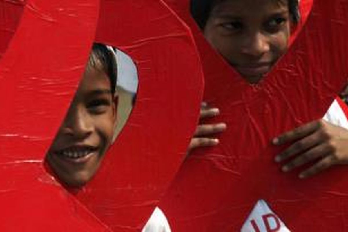 Anak-anak dan akitivis sosial turut ambil bagian dalam kampanye Hari AIDS Sedunia di Kolkata, India, Minggu (30/11/2014).