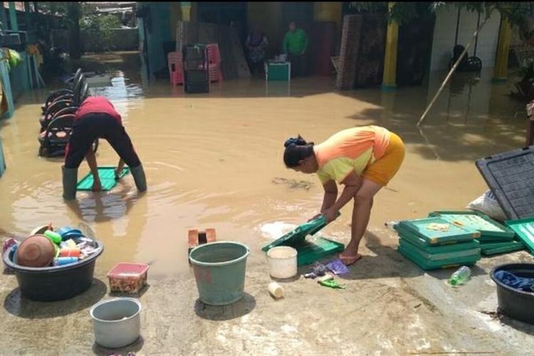 Warga Desa Karangligar, Kecamatan Telukjambe Barat, Kabupaten Karawang tengah membersihkan perabotan dari lumpur sisa banjir, Kamis (11/2/2021).