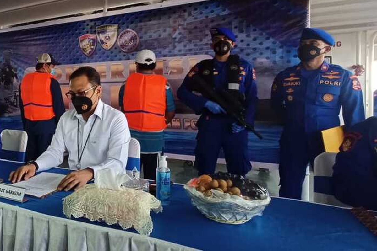 Indonesian National Police's Water Police [Polairud] official Police Brigadier General M. Yassin Kosasi holds a press conference on the capture of two Vietnamese fishing ships caught for illegal fishing on the North Natuna Sea. The captains of the vessels are in the background with there backs turned to the camera