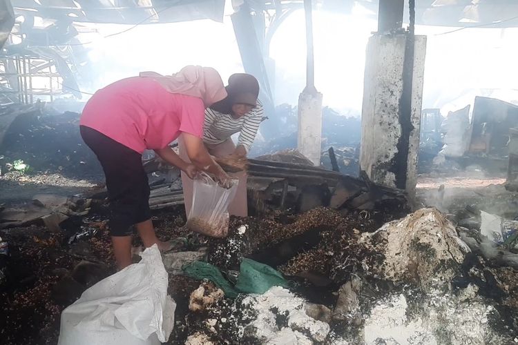 Salah seorang pedagang mengais sisa-sisa barang dagangannya yang terbakar di Pasar Ngawen, Blora, Jawa Tengah, Rabu (10/1/2024)