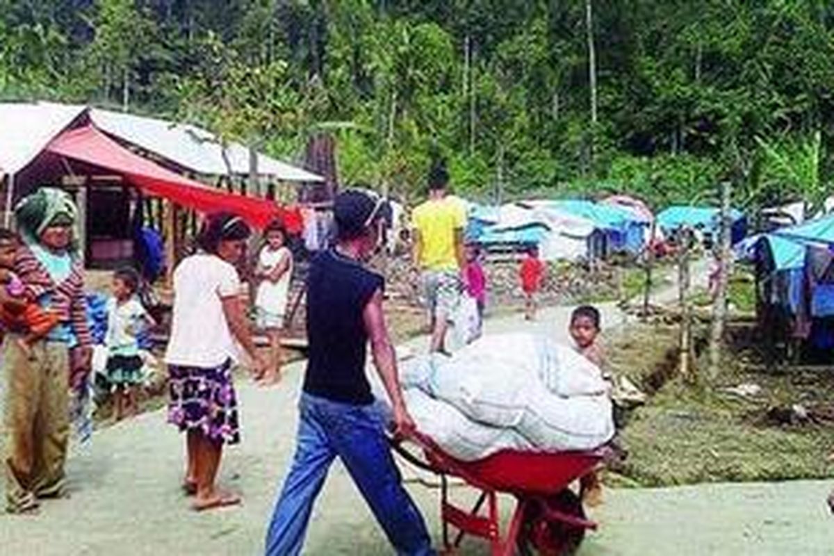 Warga Dusun Tumalei, Desa Silabu, Kecamatan Pagai Utara, Kabupaten Kepulauan Mentawai, Sumatera Barat, Selasa (21/12), beraktivitas di lokasi permukiman baru mereka. Mereka bersedia direlokasi setelah perkampungan lama musnah dihantam tsunami. Lima warga dengan sukarela menyerahkan lahan mereka untuk kebutuhan relokasi permukiman baru tanpa ganti rugi dan bergotong royong membangunnya secara mandiri.