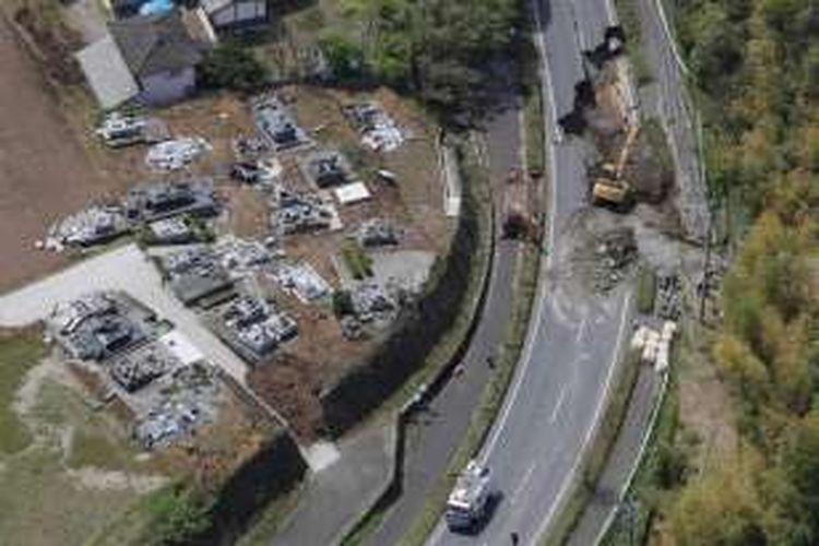 Foto diambil dari udara menunjukkan petugas memperbaiki jalan yang rusak di Kota Mashiki, prefektur Kumamoto, Jumat (15/4/2016). Gempa 6,5 SR telah mengguncang Jepang bagian selatan, Kamis malam. Sedikitnya 9 orang tewas dan ratusan lainnya luka-luka.