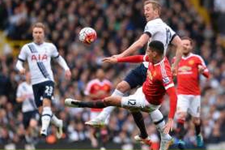 Penyerang Tottenham Hotspur, Harry Kane (atas), berduel dengan bek Manchester United, Chris Smalling, dalam lanjutan Premier League di Stadion Old Trafford, Minggu (10/4/2016).