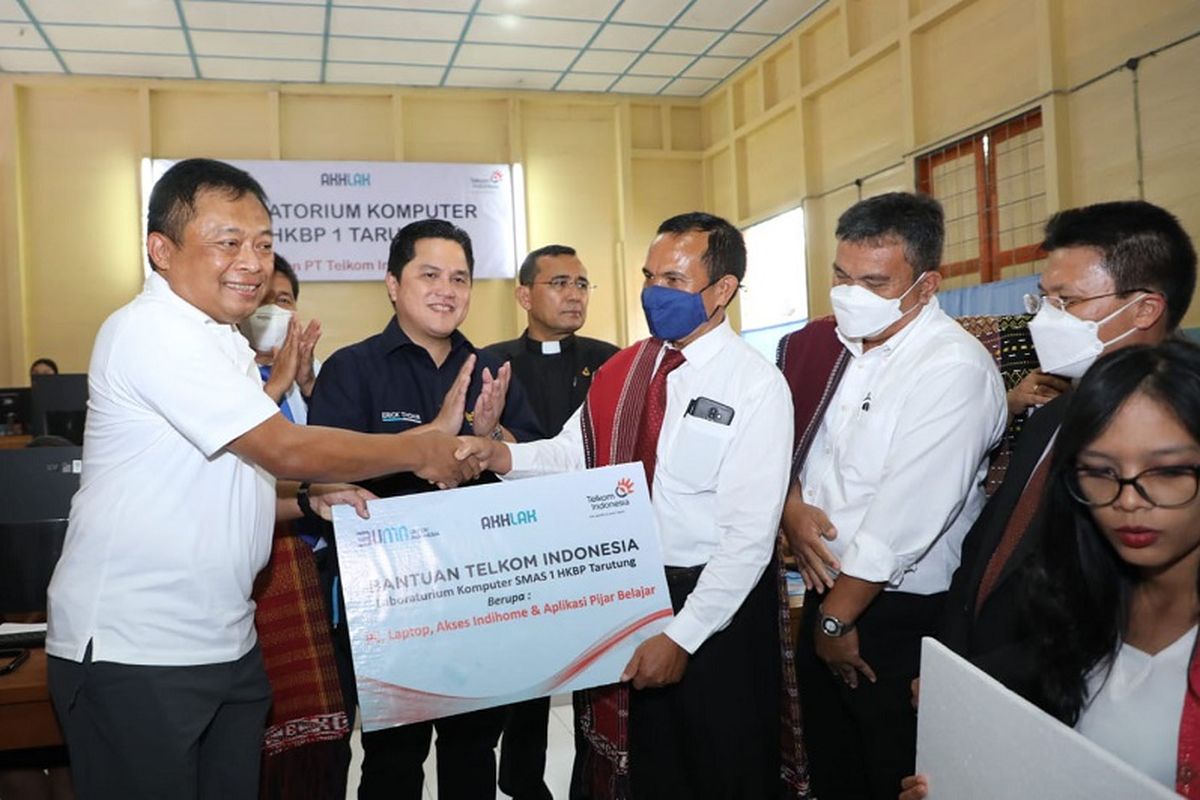 Penyerahan simbolis dukungan digitalisasi pendidikan berupa laboratorium komputer oleh Menteri Badan Usaha Milik Negara (BUMN) Republik Indonesia (RI) Erick Thohir (ketiga dari kiri) didampingi Direktur Utama Telkom Ririek Adriansyah (paling kiri) kepada Kepala Sekolah SMAS HKBP 1 Tarutung Tumbur Silaban, Kamis (19/5/2022). 