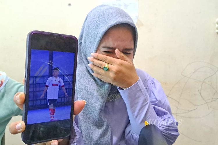 Anggun Anggriani (32), ibu almarhum Afif Maulana (13), menunjukkan foto anaknya sambil menahan tangis di kantor LBH Padang, Kota Padang, Sumatera Barat, Senin (24/6/2024).