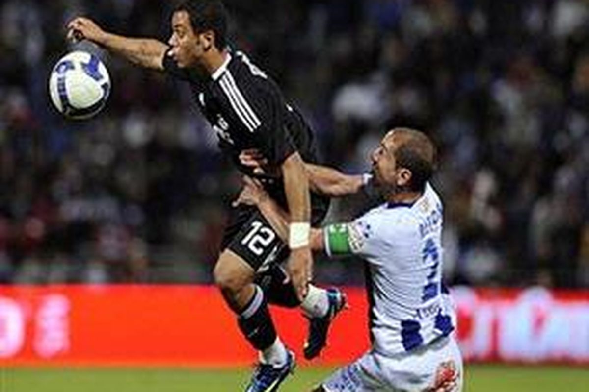 Bek Real Madrid, Marcelo dikawal ketat pemain recreativo Huelva, Aitor Tornavaca dalam pertandingan Senin (20/4) dini hari WIB. Marcelo mencetak gol tunggal kemenangan Madrid.