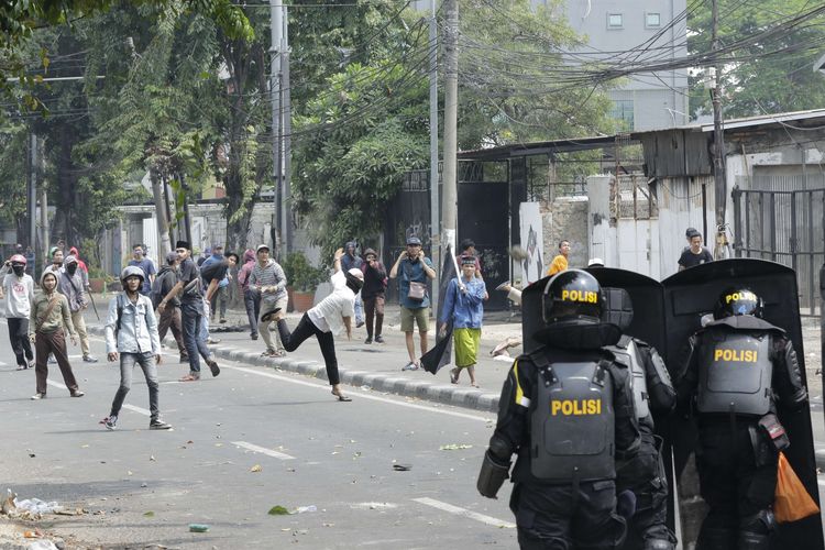 Polisi berhadapan dengan warga saat terjadi kericuhan di Jalan Brigjen Katamso, Jakarta, Rabu (22/5/2019). Kericuhan terjadi sejak selasa (21/5/2019) malam dan berlangsung hingga Rabu siang