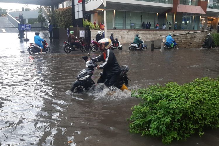 Seorang pengendara motor terpaksa menuntun kendaraannya usai menerobos banjir di Jalan Kemang Raya, Mampang Prapatan, Jakarta Selatan, Rabu (3/4/2024).
