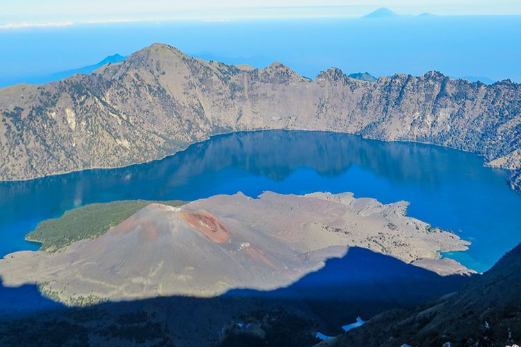Segara Anak dan Gunung Baru Jari di Gunung Rinjani. Sementara di ufuk barat, tampak atap tertinggi Pulau Dewata, yakni Gunung Agung.
