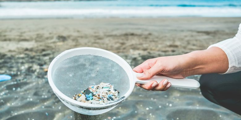 Ilustrasi mikroplastik di pantai yang mencemari laut. Dampak sampah plastik di lautan.