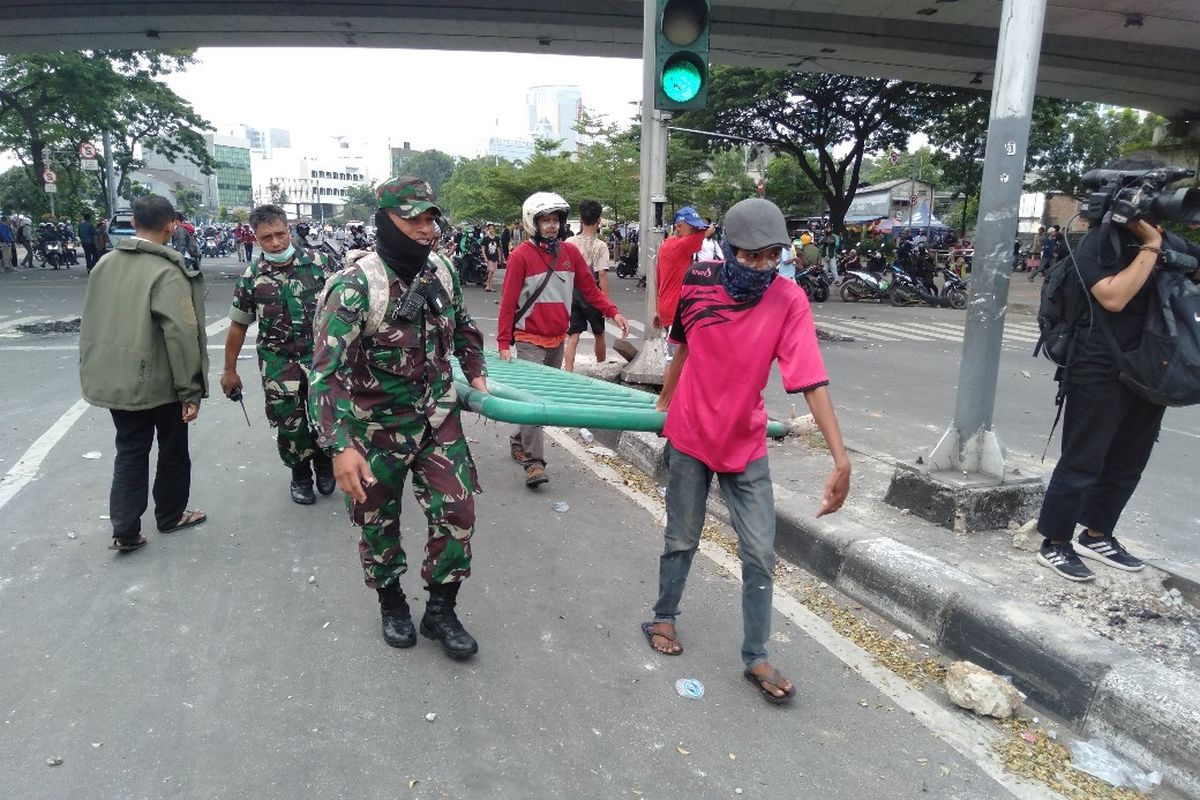 TNI dan Anggota Masa Alis 22 Mei Saling Bantu Bereskan Besi Trotoar Yang Lepas di Jalan Jati Baru Raya, Tanah Abang, Jakarta Pusat, Rabu (22/5/2019)