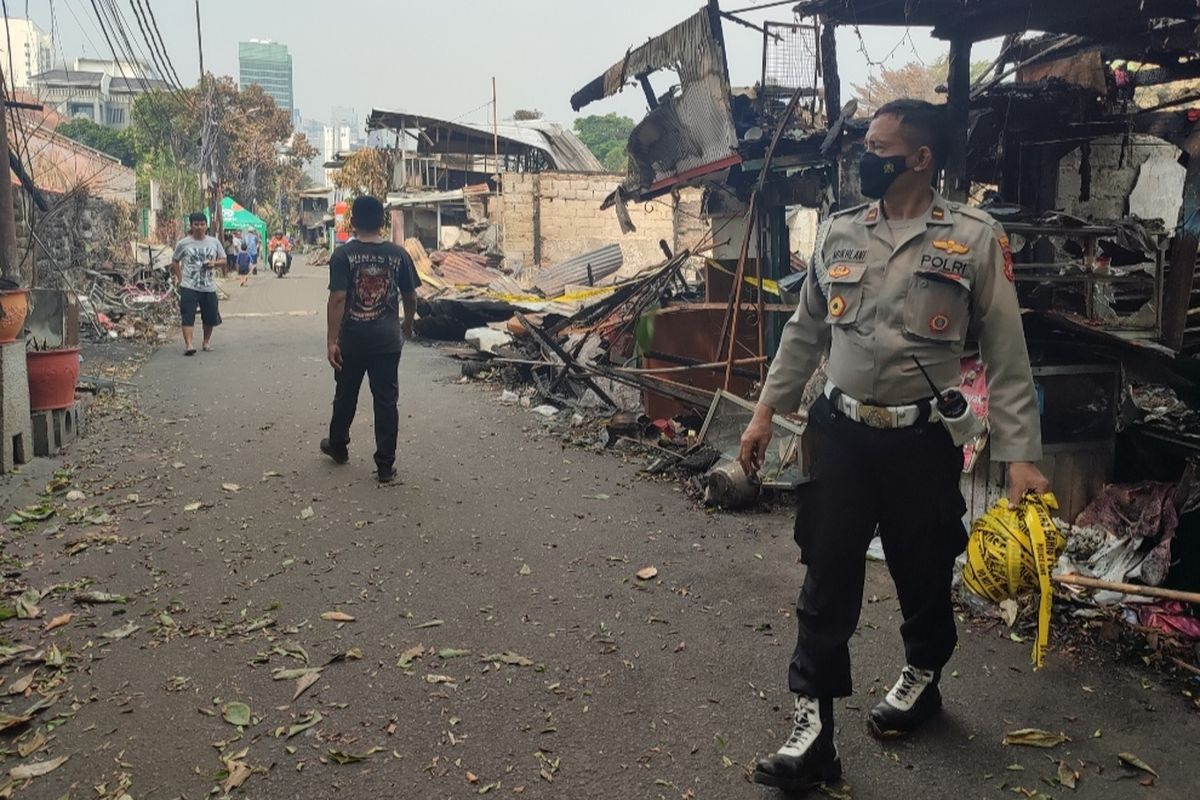 Polisi mencopot police line yang terpasang mengelilingi tempat kejadian perkara (TKP) rumah yang terbakar di Jalan Simprug Golf II, Kebayoran Lama, Jakarta Selatan, Rabu (24/8/2022).